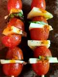 Brochette de tomates cherry con queso y albahaca