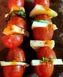 Brochette de tomates cherry con queso y albahaca