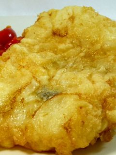 Una foto de Bacalao rebozado acompañado de pimientos