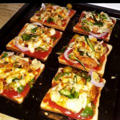 A picture of Bread pizza and fresh falsa juice.