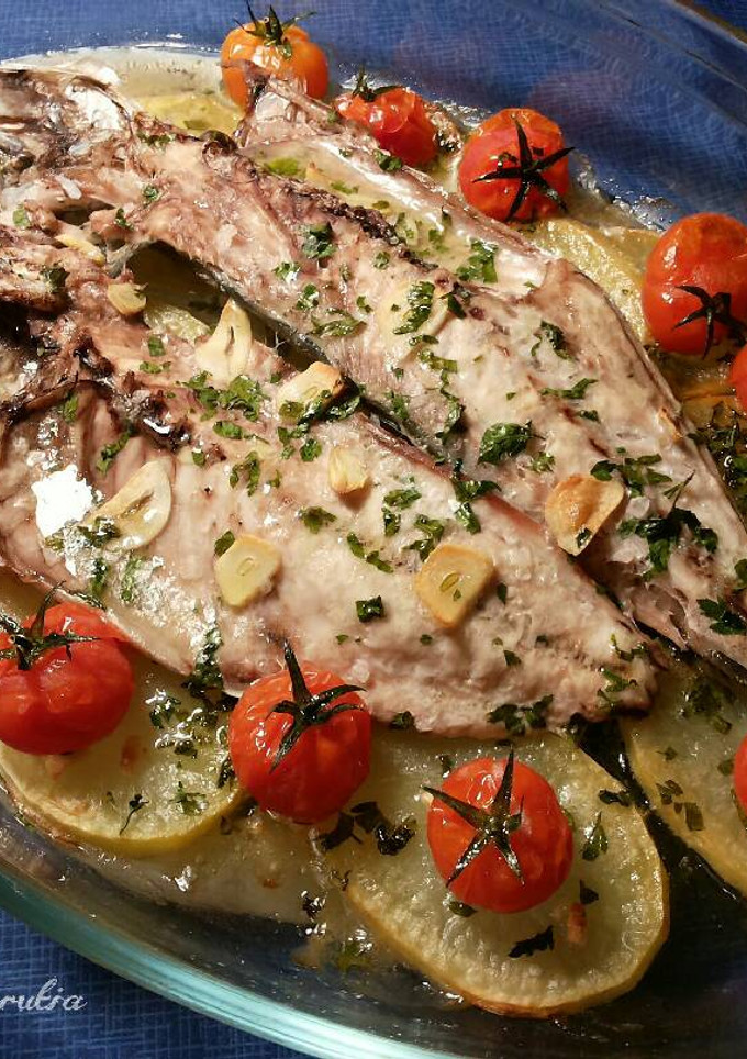 Una foto de Jurel blanco del estrecho con patatas al ajillo y cherrys asados