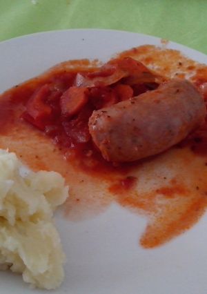 Una foto de Chorizos a la pomarola con puré de papas