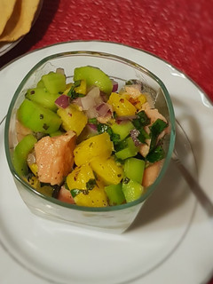 Una foto de Ceviche de salmón con piña y jugo de naranja agria