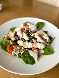Una foto de Ensalada de espinacas y pollo con salsa de yogur