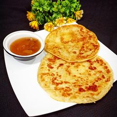 A picture of Khatti meethi karee ki chutney with paratha.