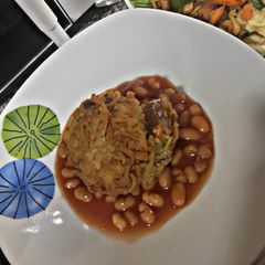 A picture of Annie's Noodles croquettes embedded in baked beans.
