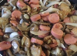 Una foto de Champiñones con tocino, cebolla, salchicha y ajo
