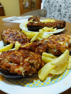 Una foto de Berenjenas rellenas de carne, y patatas fritass