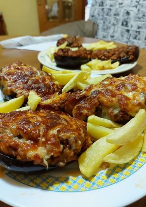 Una foto de Berenjenas rellenas de carne, y patatas fritass