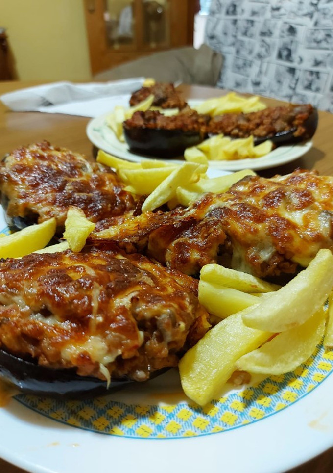 Una foto de Berenjenas rellenas de carne, y patatas fritass
