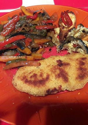 Una foto de Milanesa con verdura salteada y berenjena