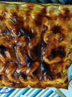 Una foto de Empanada de bacon, dátiles y queso