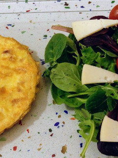 Una foto de Tortilla de jamón y ensalada de brotes tiernos