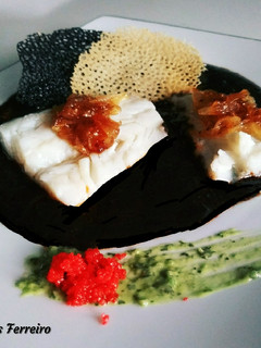 Una foto de Bacalao en tinta de calamar y crujiente de pescado