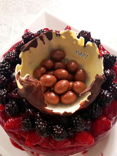 Una foto de Pastel de queso con coulis de frutos rojos y mona