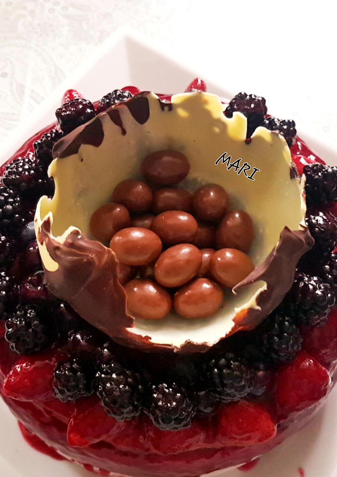 Una foto de Pastel de queso con coulis de frutos rojos y mona