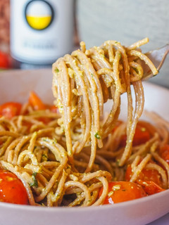 Una foto de Espaguetis integrales con pesto y cherrys