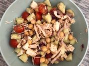 Una foto de ensalada de pollo con tomates cherry