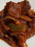 Masa de cerdo frita con salsa de tomate, pimiento y cebolla