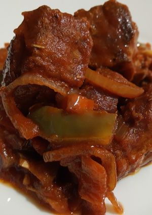 Una foto de Masa de cerdo frita con salsa de tomate, pimiento y cebolla