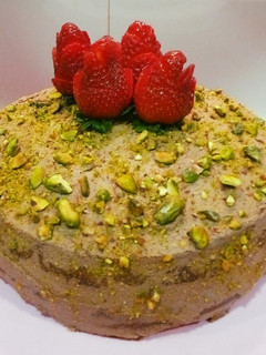 Una foto de Tarta de pistachos, trufa de chocolate, y fresas