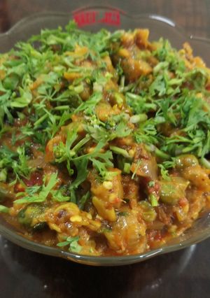 A picture of Baingun bharta with green peas.