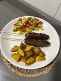 Pinchos de carne molida, papas al horno y ensalada fresca
