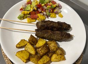Una foto de Pinchos de carne molida, papas al horno y ensalada fresca