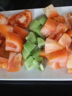 Una foto de Ensalada ordenada de naranja, tomate y kiwi