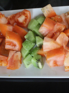 Una foto de Ensalada ordenada de naranja, tomate y kiwi