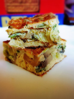 Una foto de Tortilla de champiñones y hojas tiernas