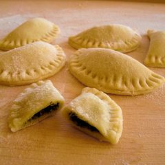 A picture of Dumplings (pierogi) with spinach.