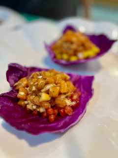 Una foto de Tartar de salmón y Granada (o mango) sobre hoja de lombarda
