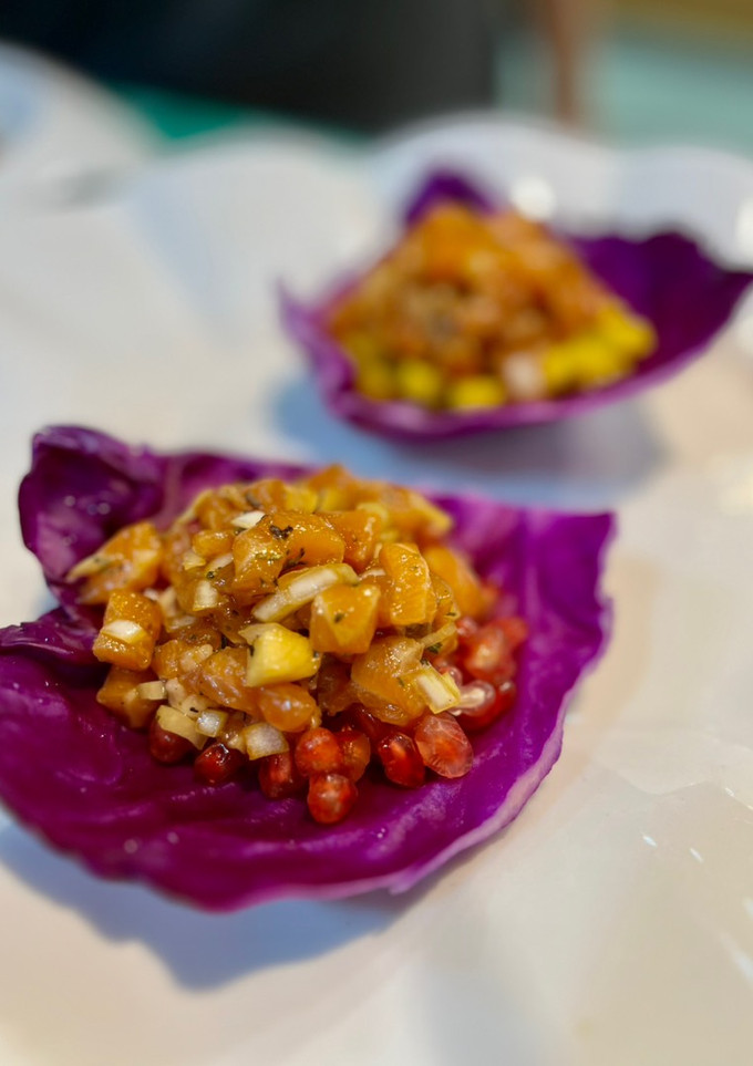 Una foto de Tartar de salmón y Granada (o mango) sobre hoja de lombarda