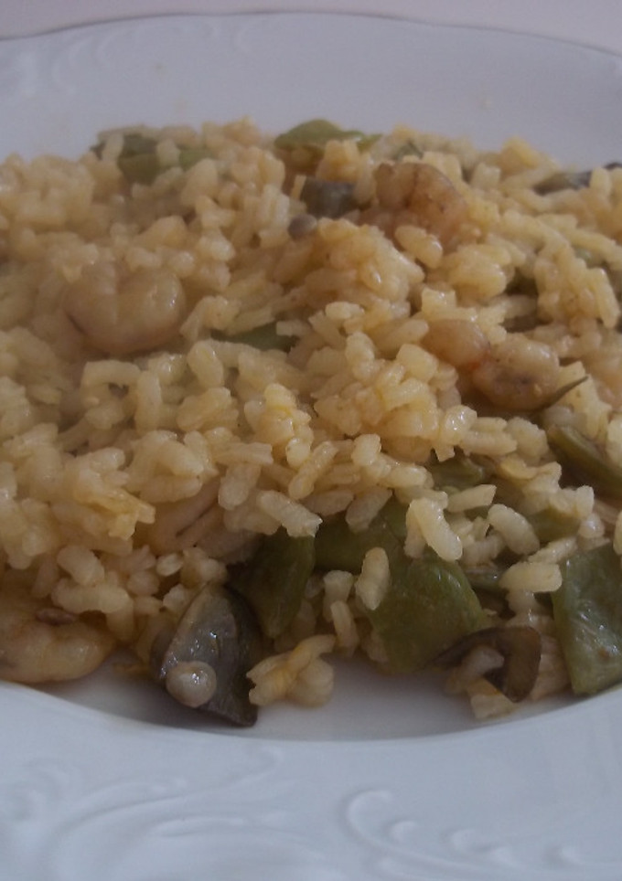 Una foto de Arroz seco con caldo de pescado, gamba pelada, judías y alcachofas