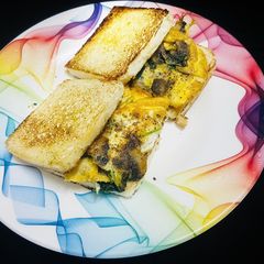A picture of Mushroom, spinach, egg omelette sandwich.