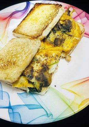 A picture of Mushroom, spinach, egg omelette sandwich.