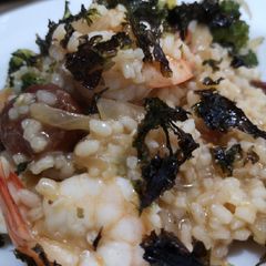 A picture of Fusion risotto. Prawn, chorizo and broccoli topped with seaweed.