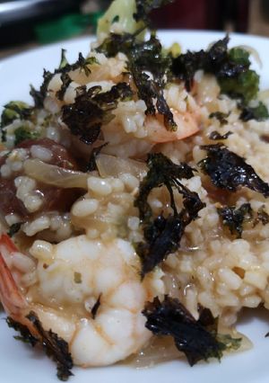 A picture of Fusion risotto. Prawn, chorizo and broccoli topped with seaweed.