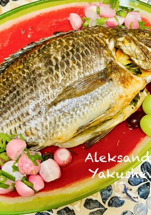 A picture of Tilapia baked with carrots and onions.