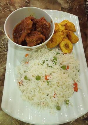 A picture of Rice and chicken stew with plantain. My love for rice and stew.