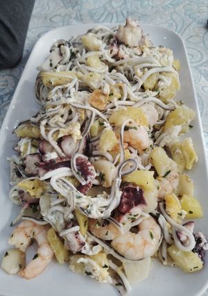 Una foto de Pulpo con gulas, langostinos, patatas y huevos rotos