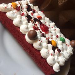 A picture of Red valvet cake covered with whipped cream.