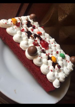 A picture of Red valvet cake covered with whipped cream.