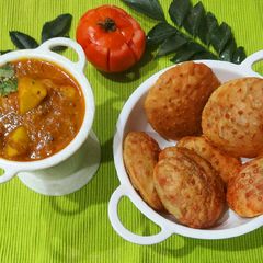 A picture of Aloo Tamater Curry with Beetroot Puri.