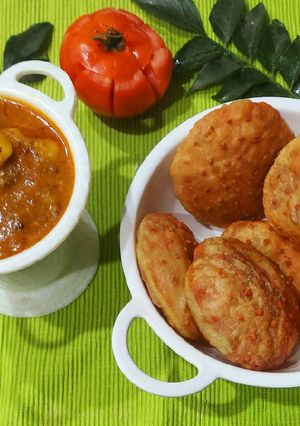 A picture of Aloo Tamater Curry with Beetroot Puri.