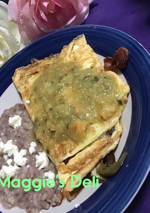 Una foto de Omelette de tocino y pimientos bañada con salsa verde con habanero