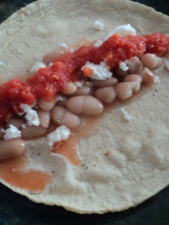 Una foto de Tacos de frijol de la olla con salsa de chorizo y tomatillo cherry con chile de árbol rojo