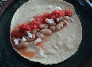 Una foto de Tacos de frijol  de  la olla con salsa de chorizo y tomatillo cherry con chile de árbol rojo