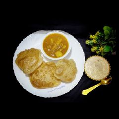 A picture of Poori- aloo curry and kheer.